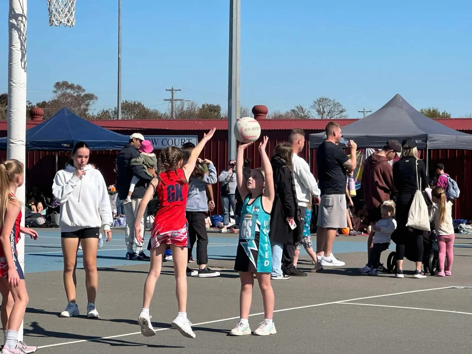 Junior netball at Dookie United — young player shooting for goal