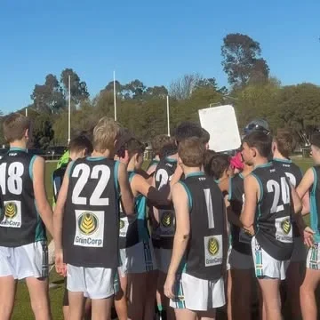 Dookie United junior football team in a pre-match huddle on the oval